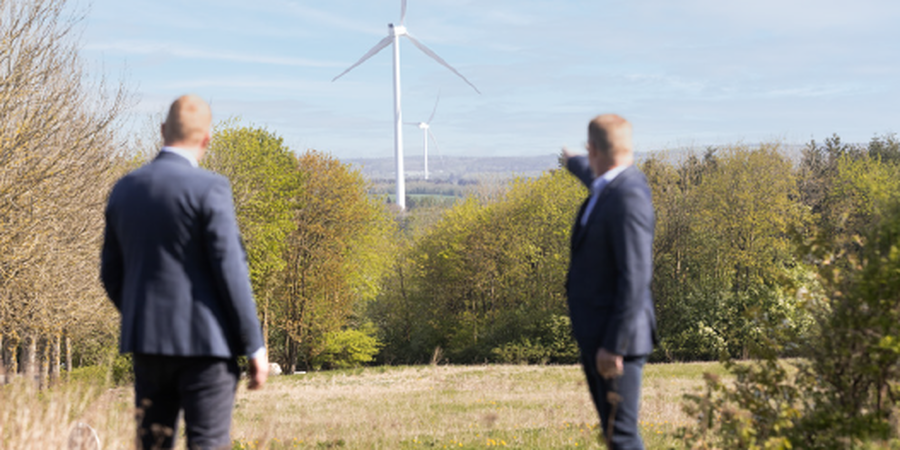 Energiselskaber vil gerne opkøbe landbrugsjord for at opføre solpaneler og vindmøller, ofte som optionsaftaler. EDC mæglere står og peger på vindmøller i horisonten.