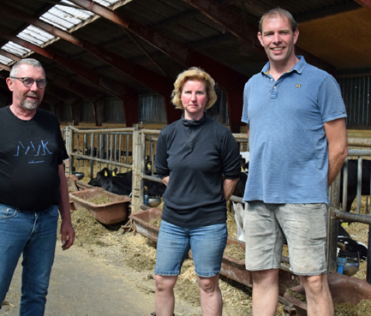 Ejerne står i deres kostald sammen med sælgeren.